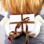 beautiful blonde woman holding a christmas gift is smiling