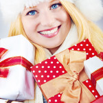 beautiful blonde woman holding a christmas gift is smiling